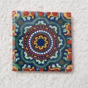 Colorful mandala ceramic tile on white towel