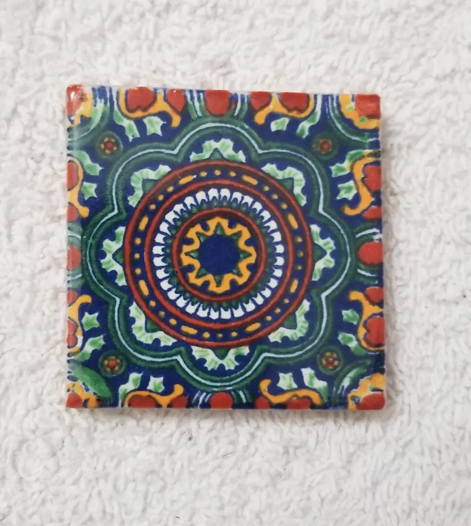 Colorful mandala ceramic tile on white towel