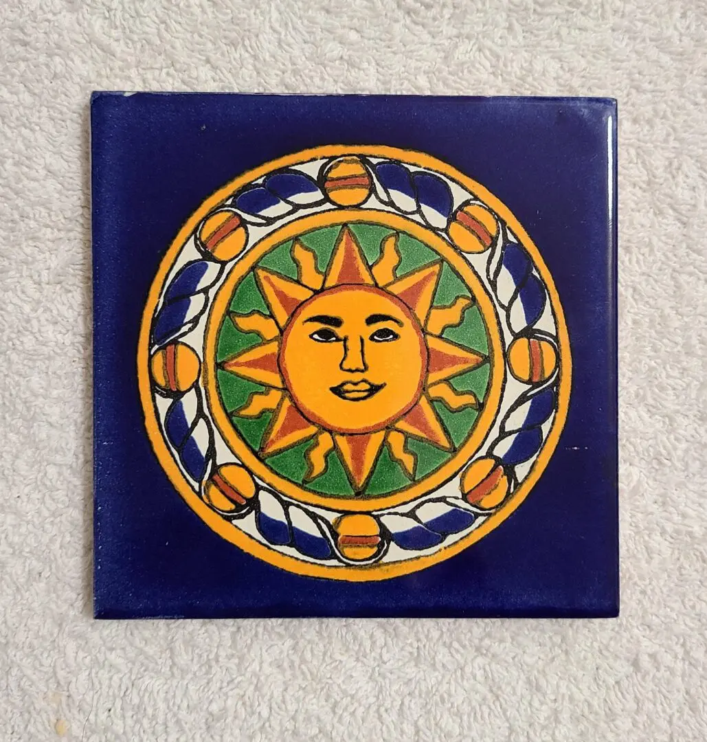 Colorful sun design on decorative ceramic tile.