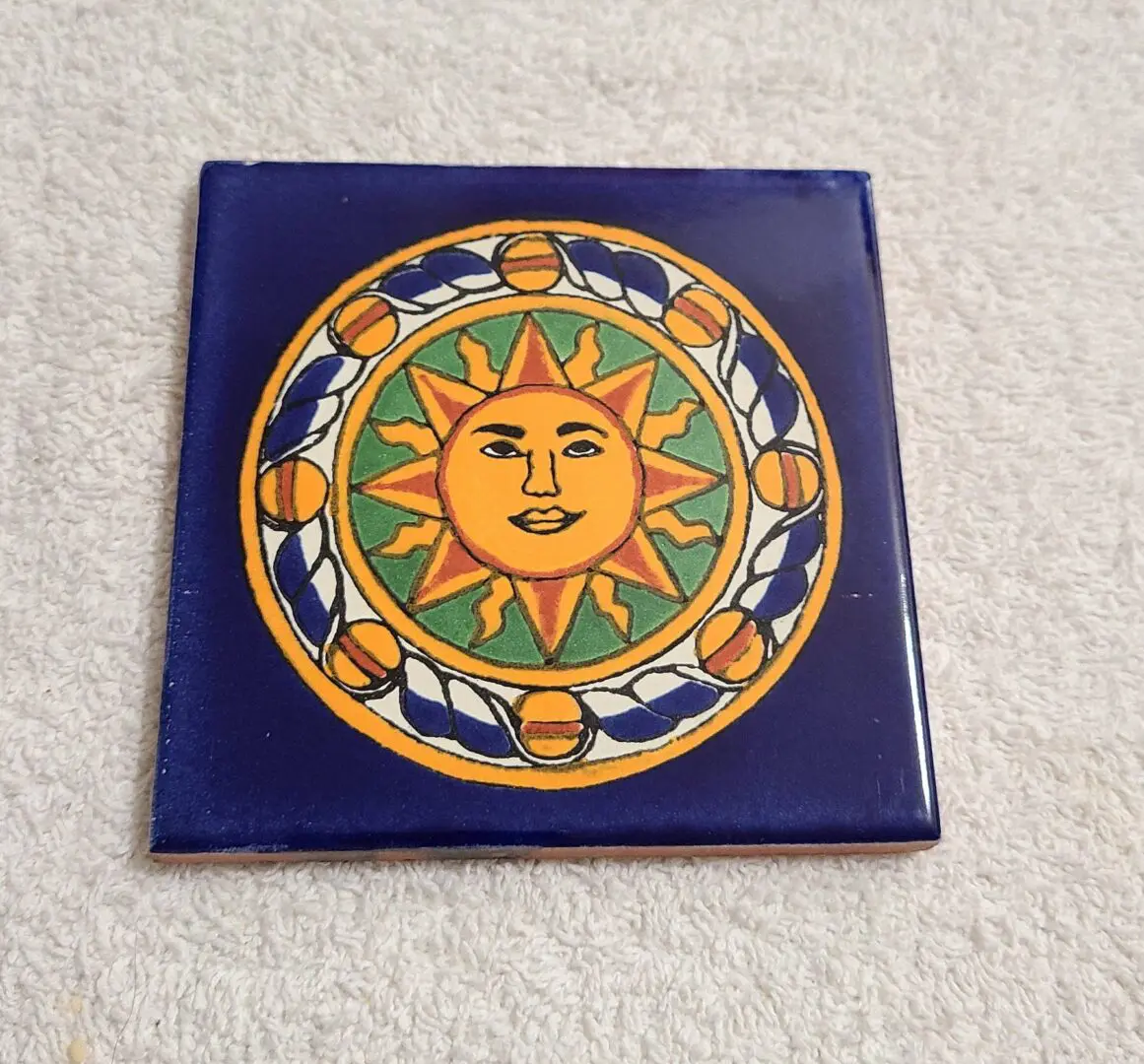 Decorative tile with sun design on fabric.