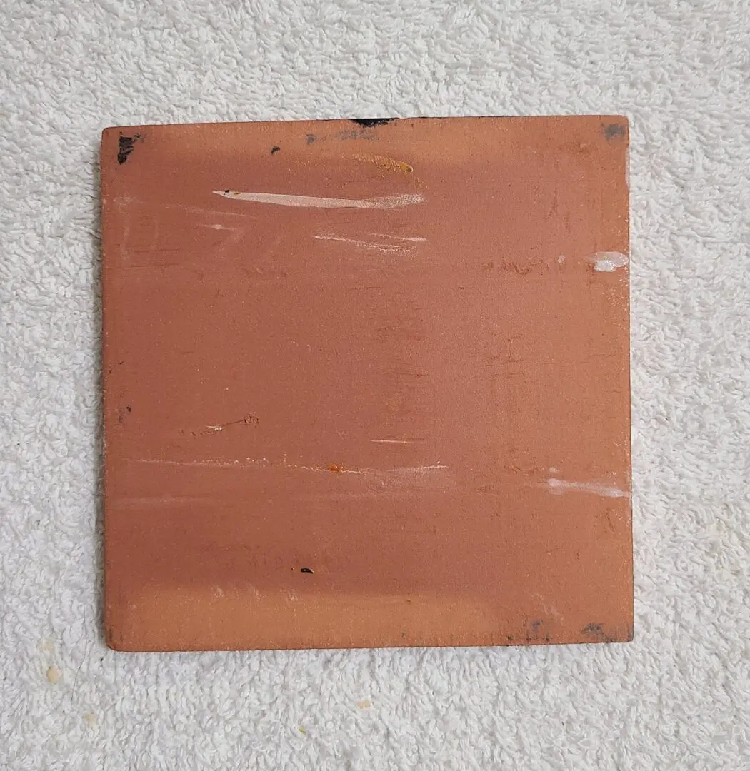 Brown ceramic tile on white surface.