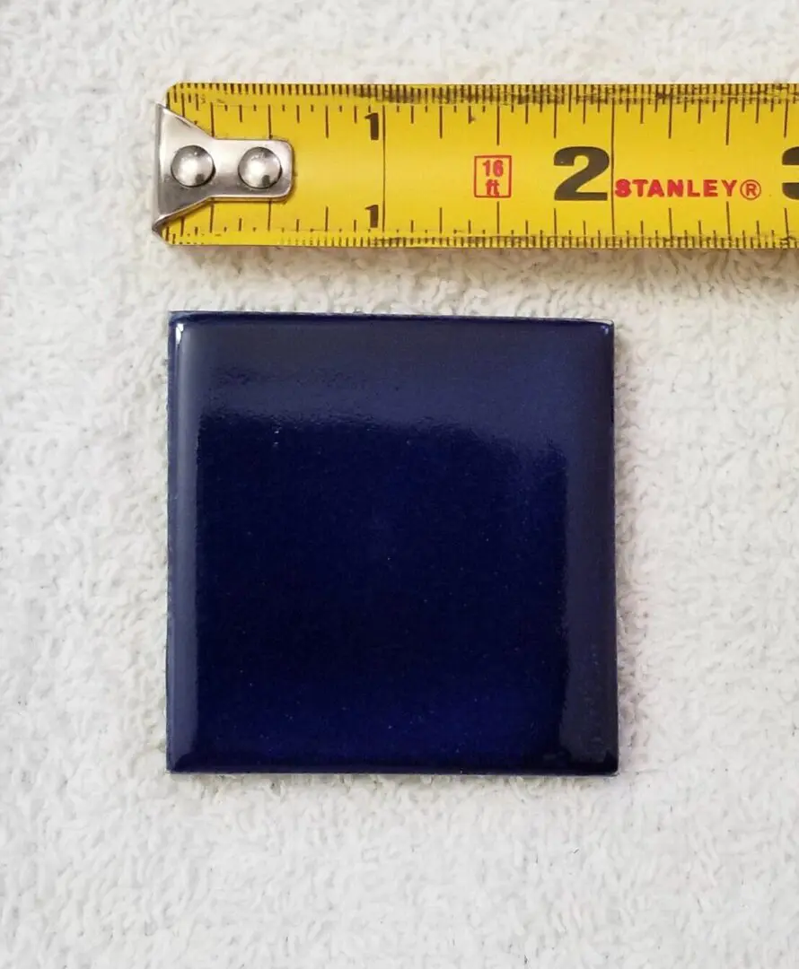 Blue tile with measuring tape above it.