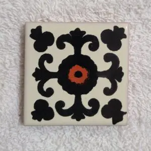 Decorative tile with black and orange design.