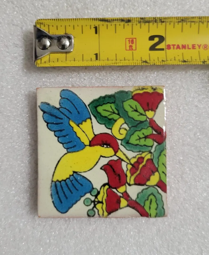 Colorful bird tile with measuring tape.