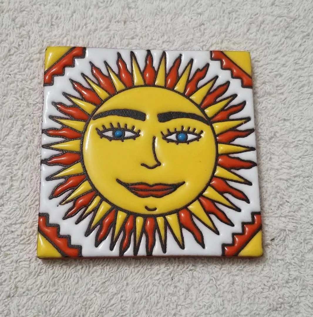 Colorful sun face design on ceramic tile.