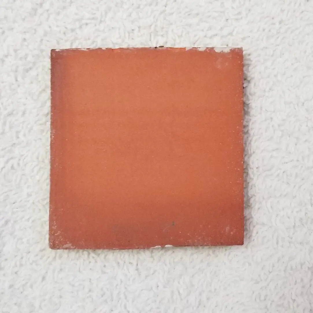 Square orange tile on white background.