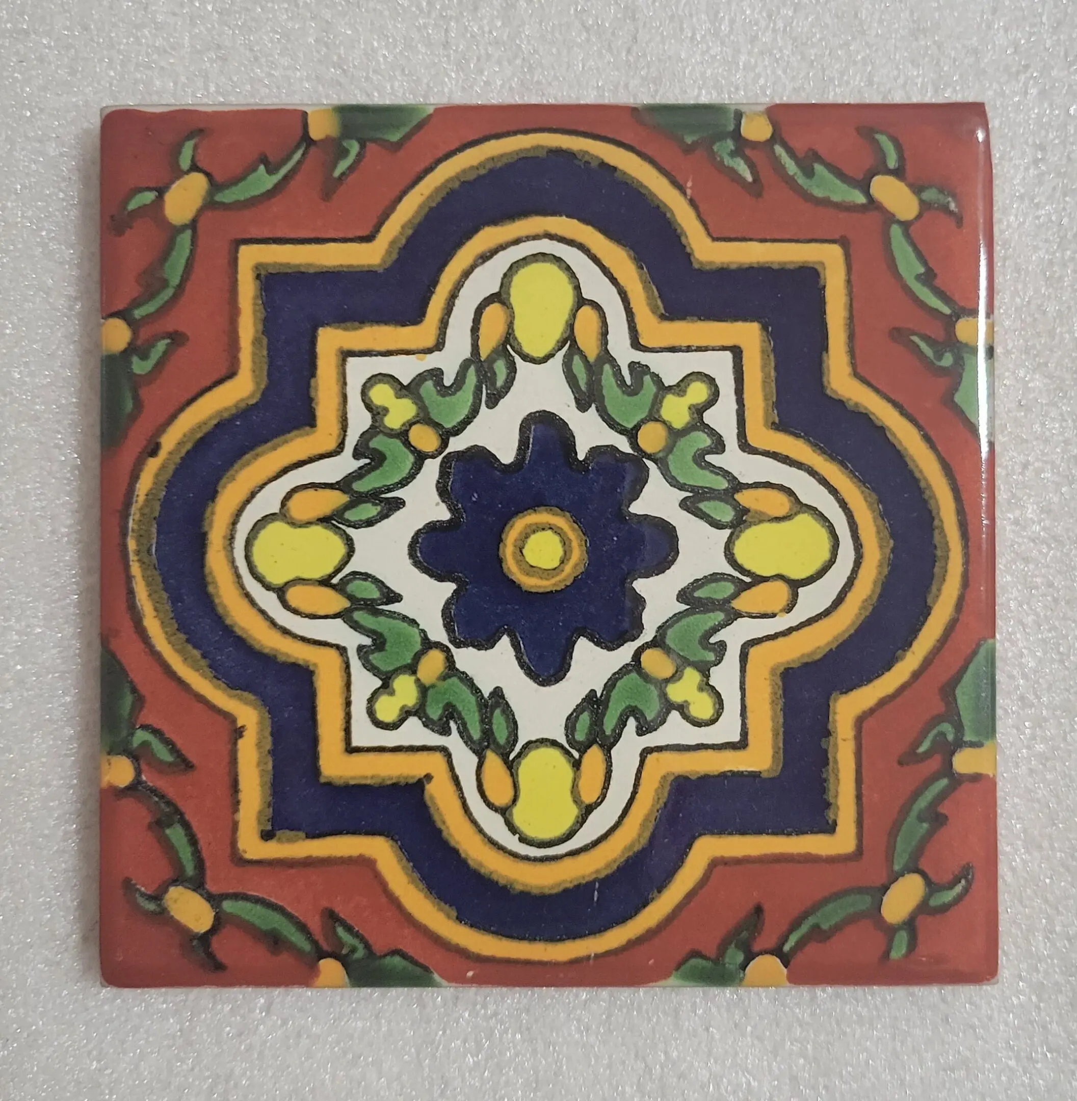 Colorful, intricate ceramic tile with floral pattern.