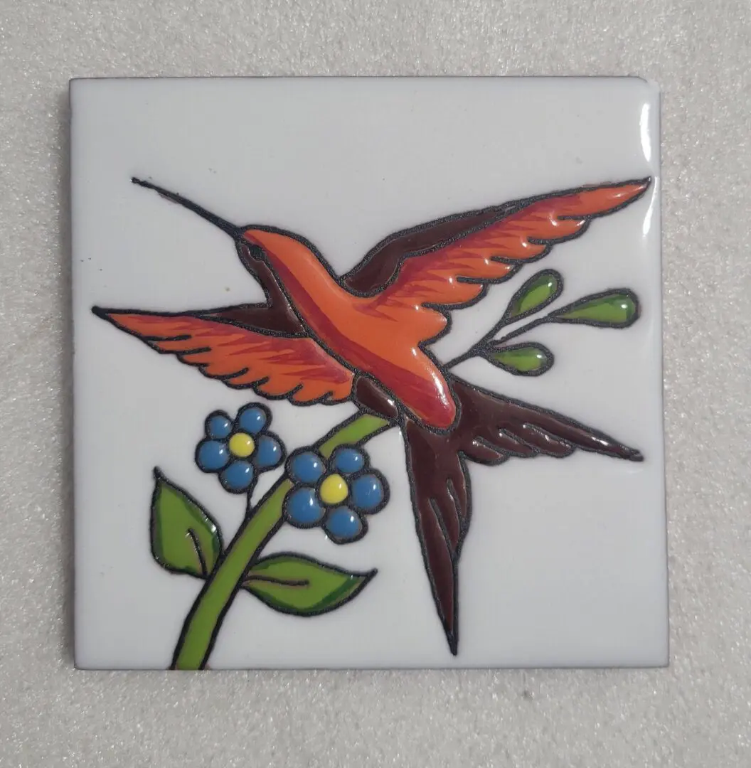 Tile with a colorful bird and floral design.