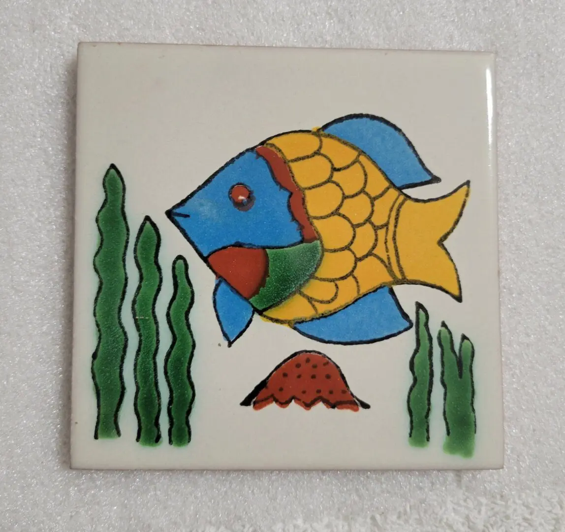 Colorful fish and seaweed on decorative tile.