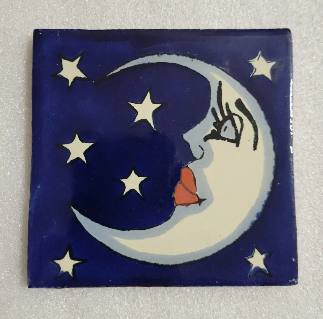 Moon with face and stars on tile.