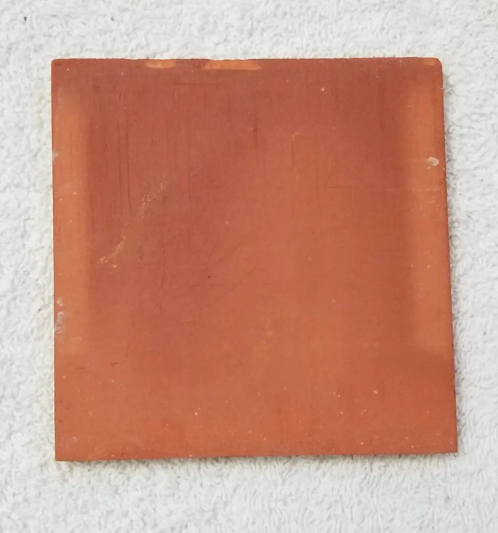 Red square tile on white surface.