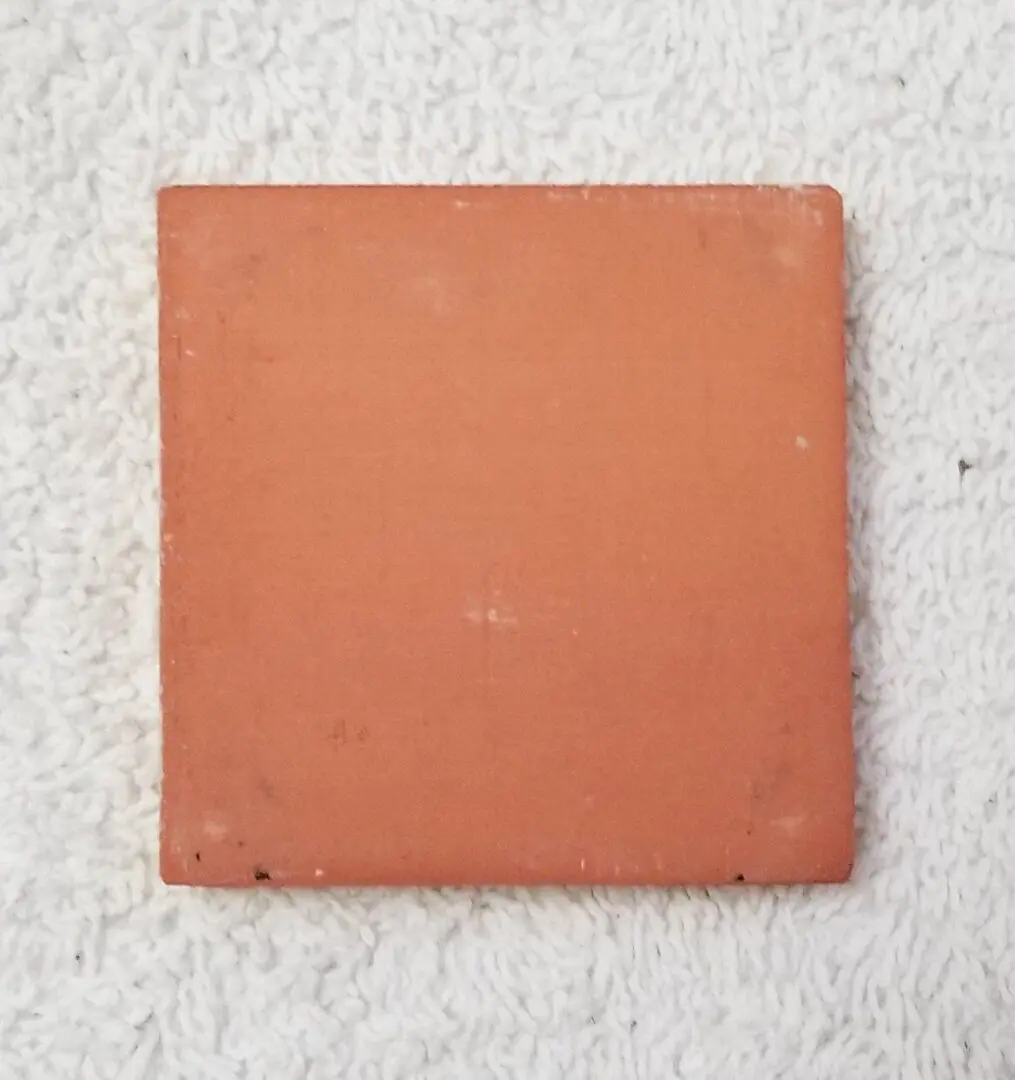 square terracotta tile on white towel