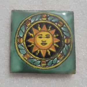 Decorative tile featuring a sun and moon design in vibrant colors.