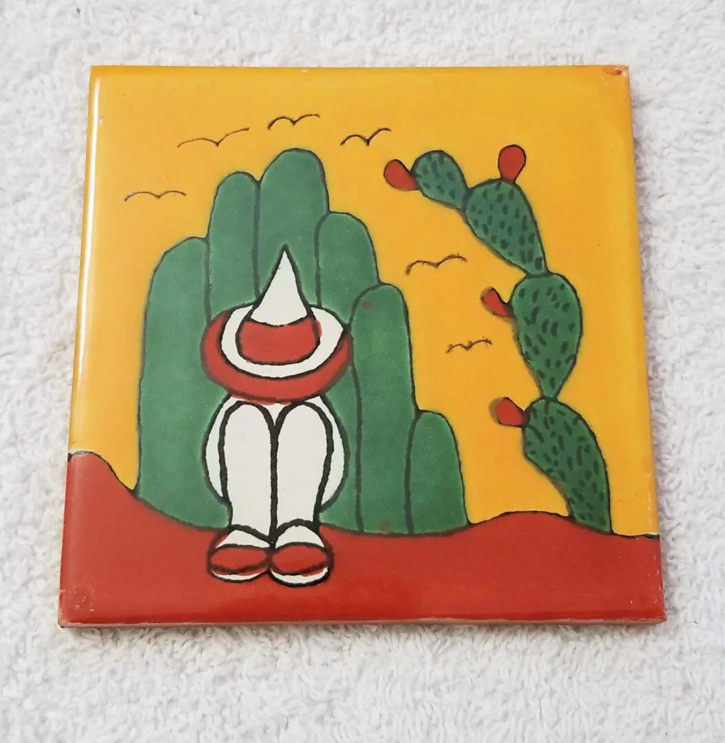 Cartoon figure sitting near cactus and mountains.