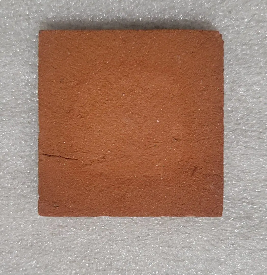 Square piece of reddish-brown leather on a gray surface.