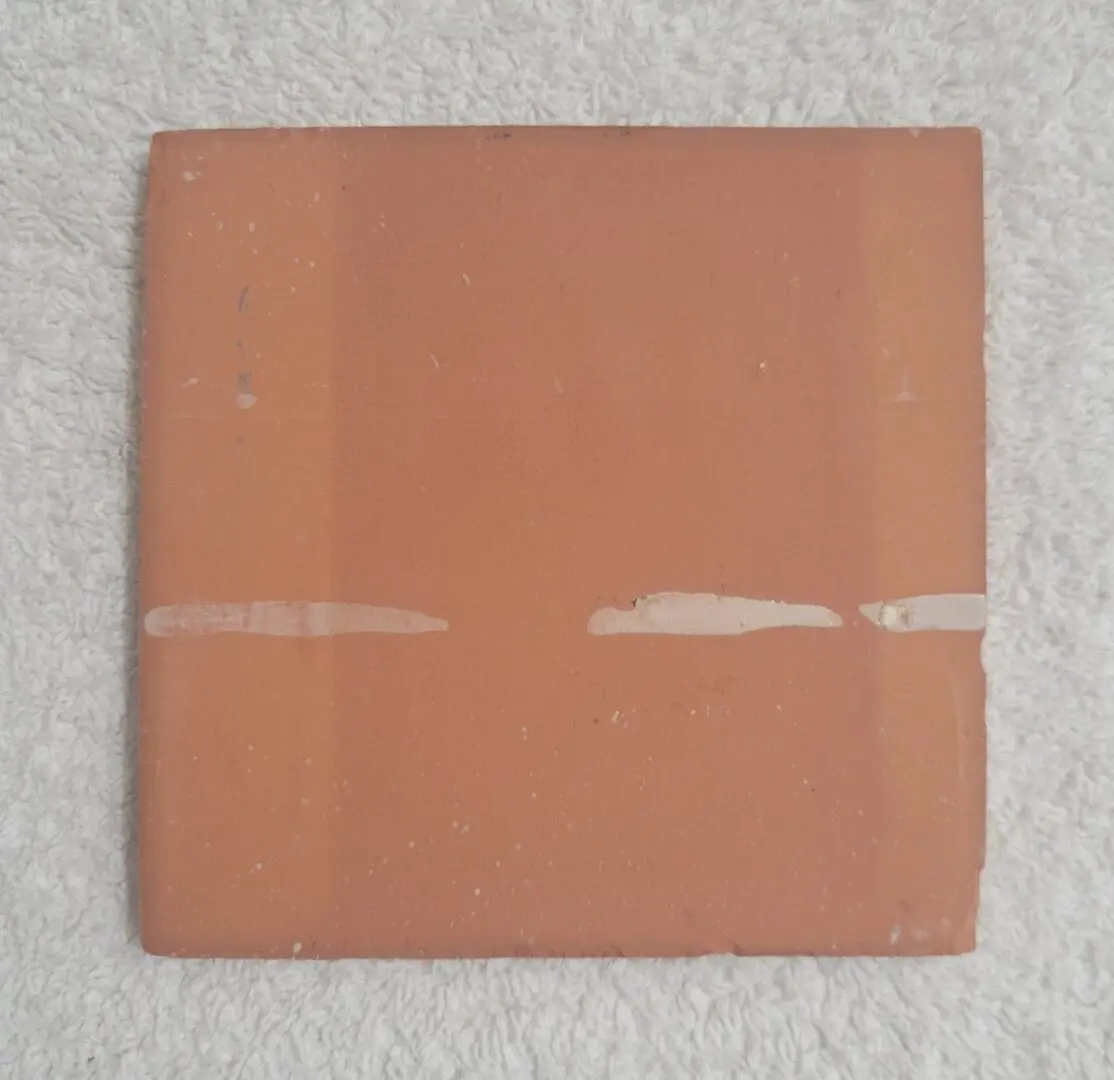 Square terracotta tile with white glaze streaks