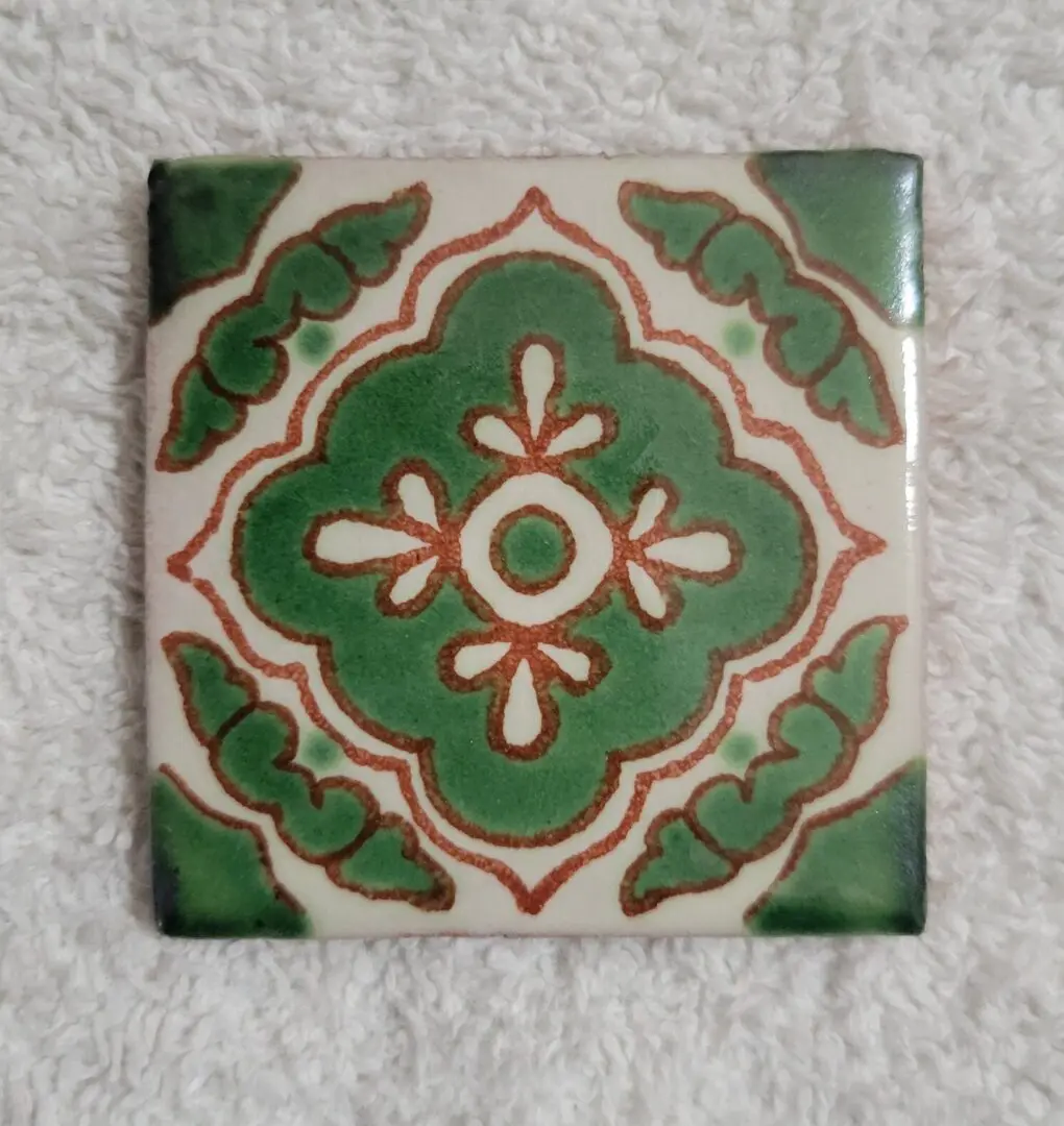 Decorative tile with green and brown pattern.