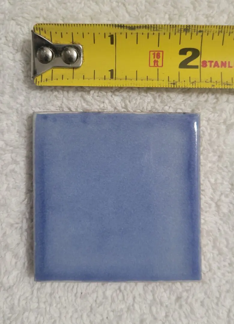 Blue tile with yellow measuring tape.