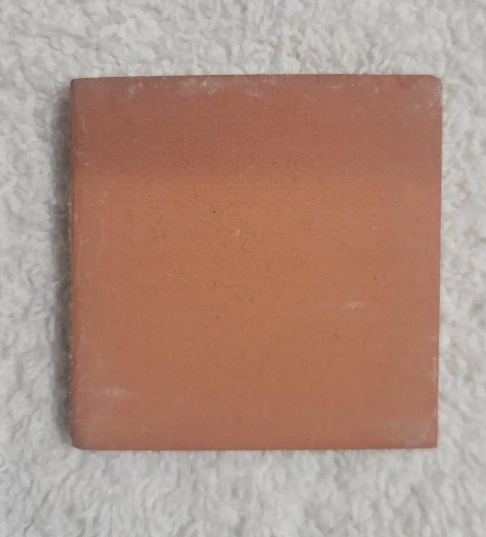 A square terracotta tile with a plain, unglazed surface.