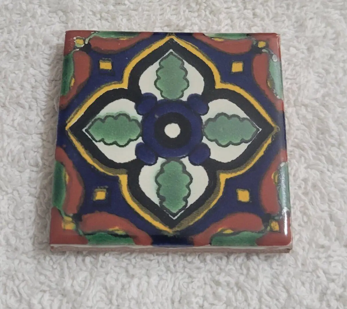 Colorful geometric patterned ceramic tile on fabric.