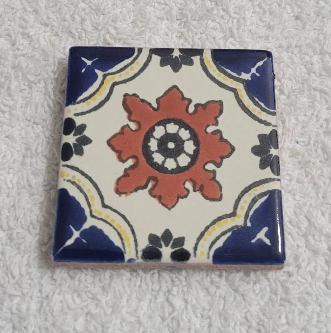 Decorative ceramic tile with red floral motif