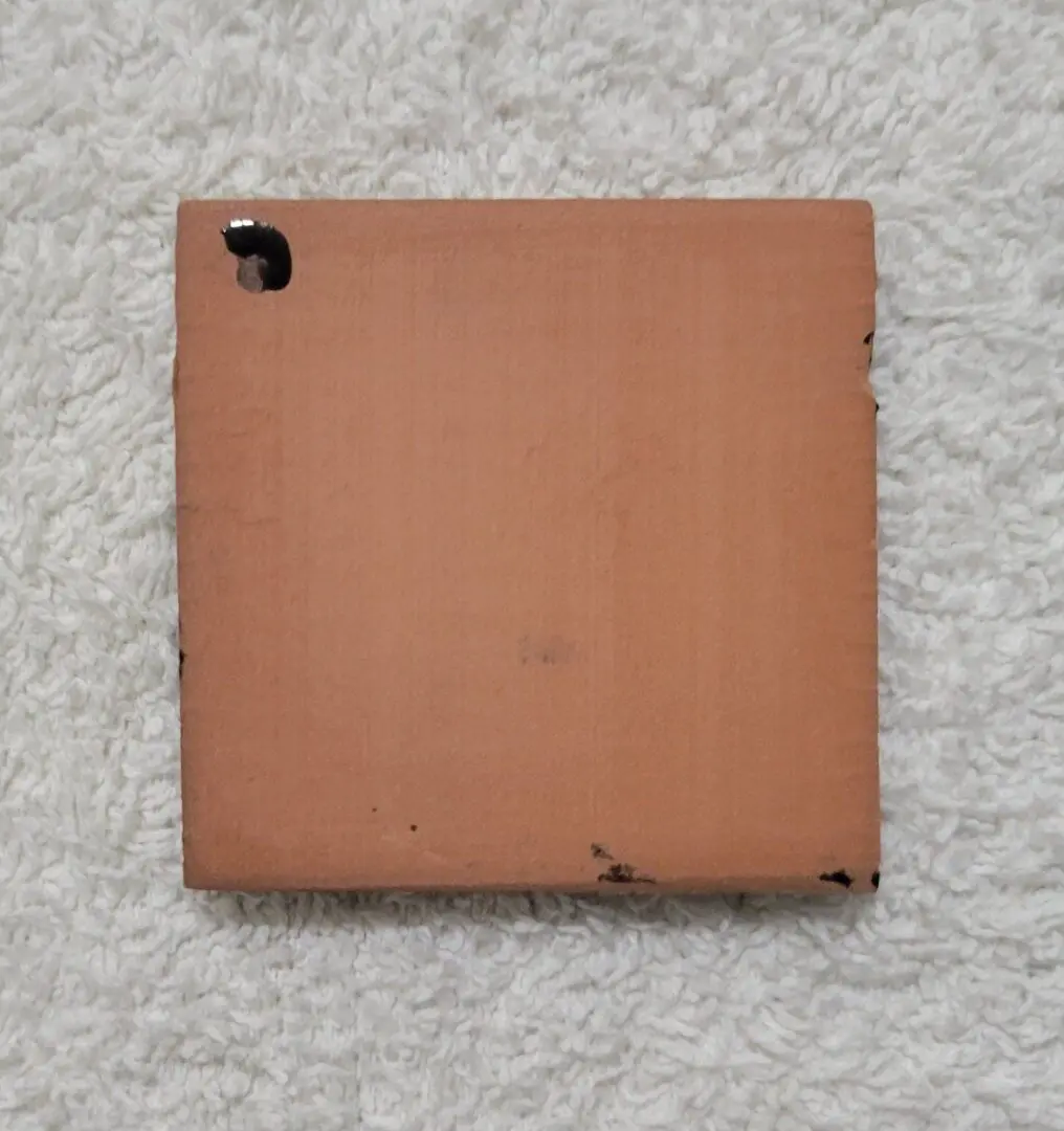 A square cardboard piece with a small cutout on one corner.