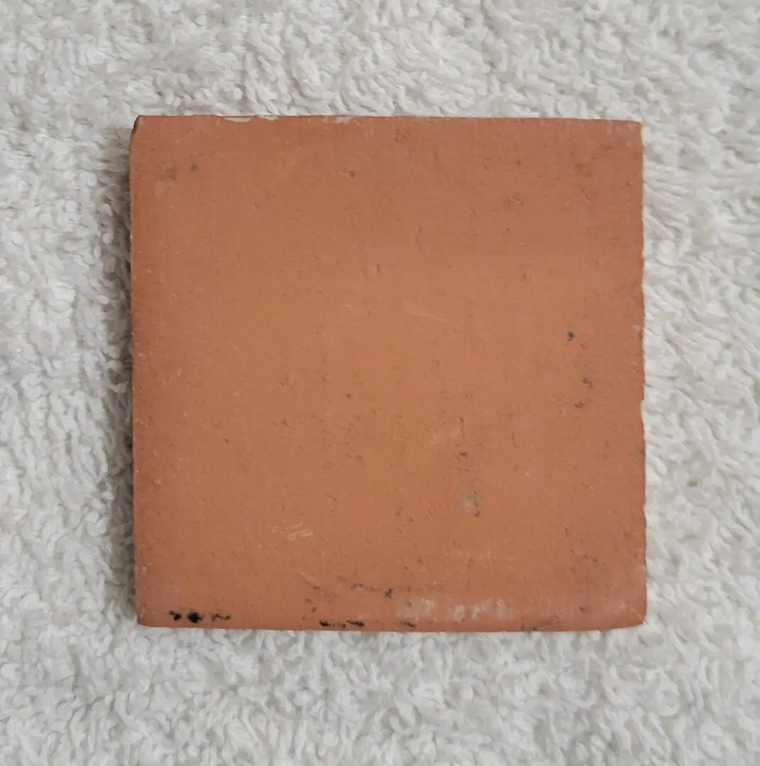 Terracotta square tile on white textured background