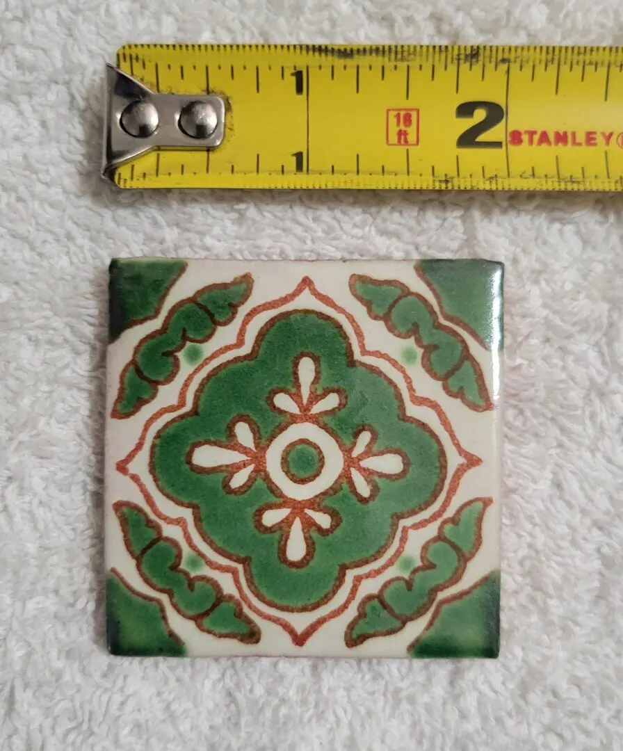 Decorative tile with green pattern and ruler.