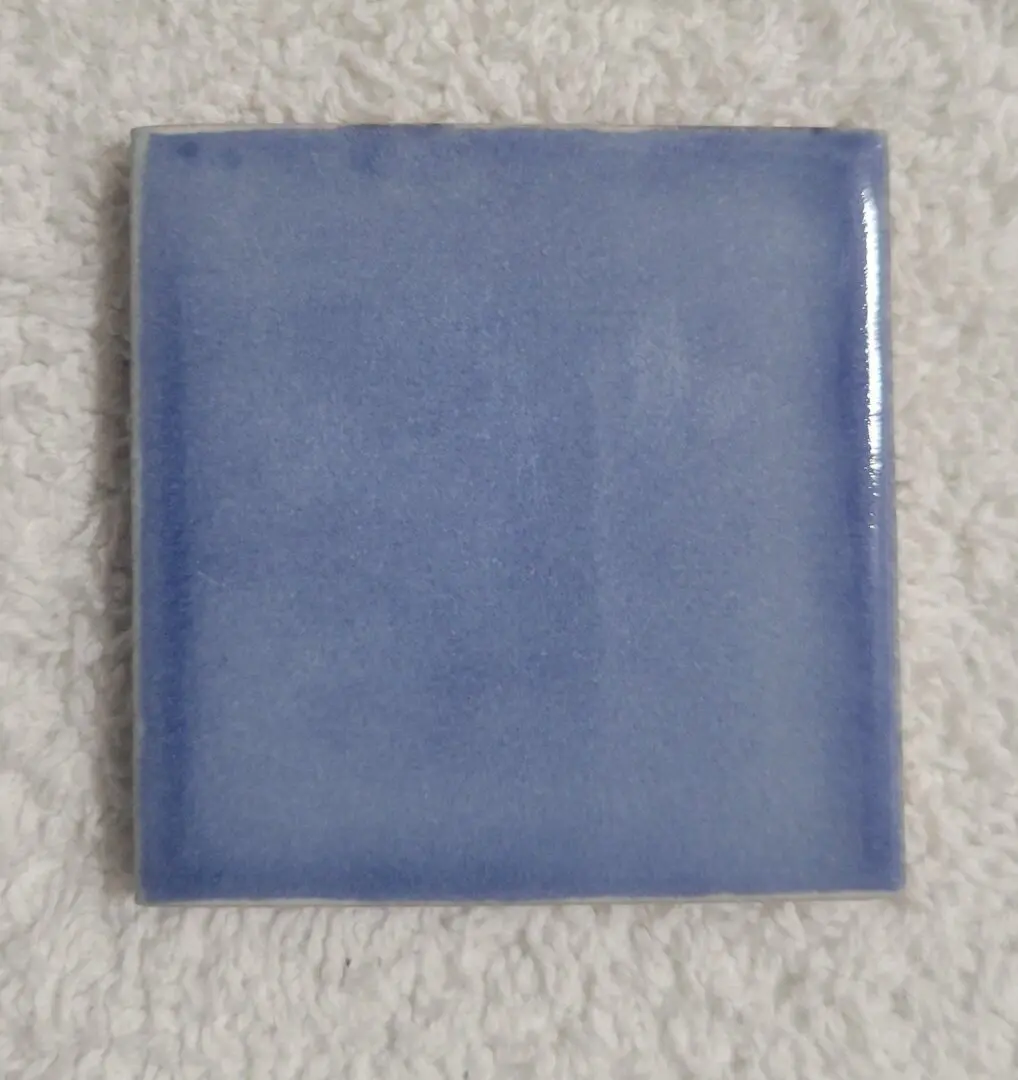 Blue square ceramic tile on white background.