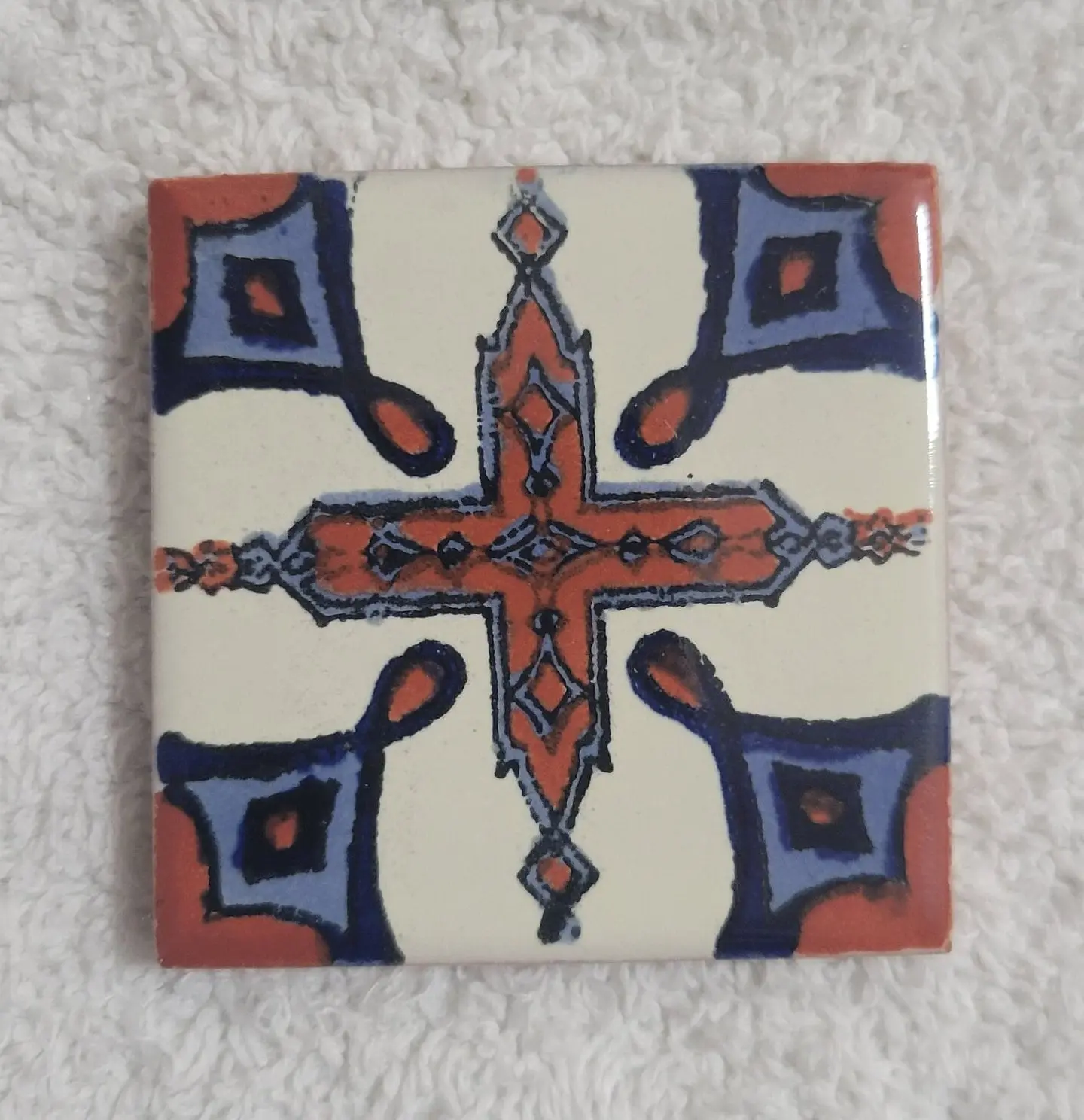 Decorative ceramic tile with orange-blue motif