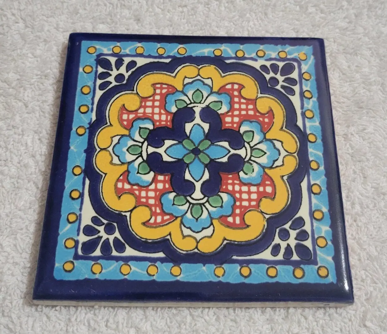 Hand-painted ceramic tile with colorful floral motif