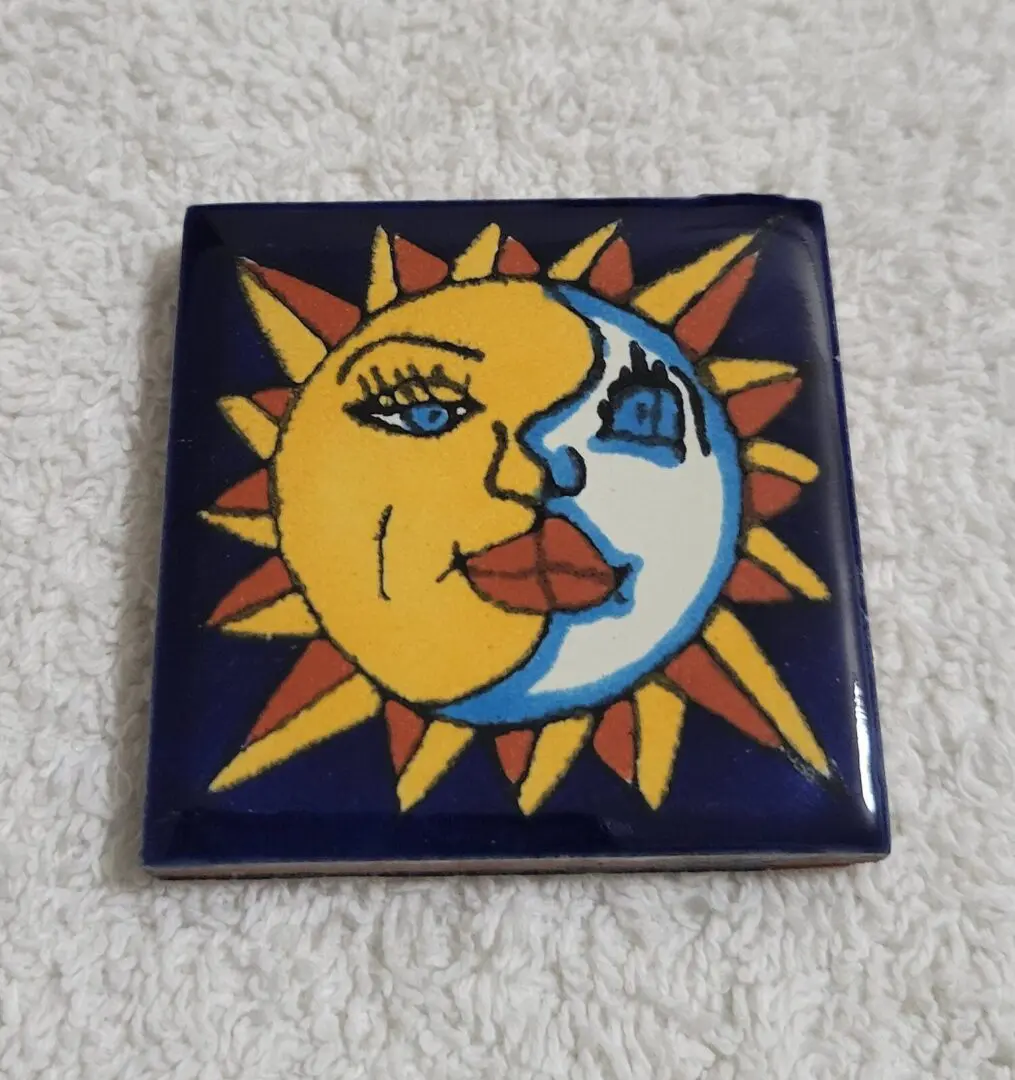 Sun and moon face design tile with vibrant colors.