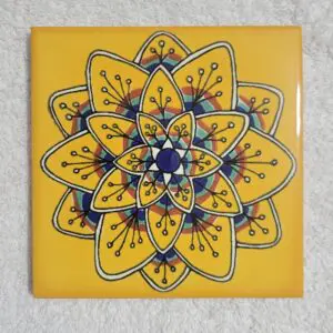 Decorative yellow tile with intricate floral and geometric patterns in blue and white.