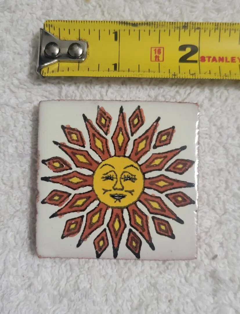 Decorative sun tile with a measuring tape beside it.