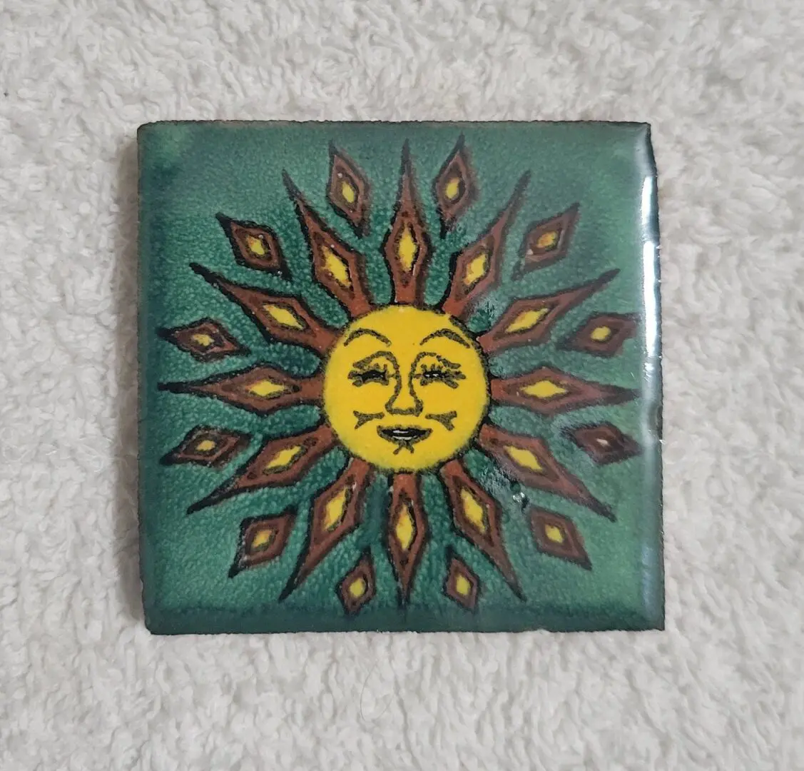 Colorful sun design on decorative tile.