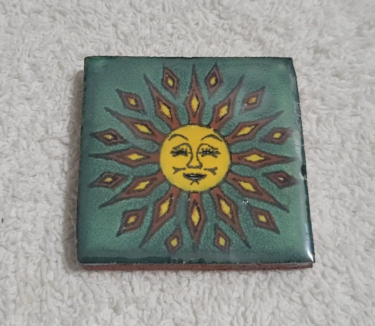 Ceramic tile with sunburst design.