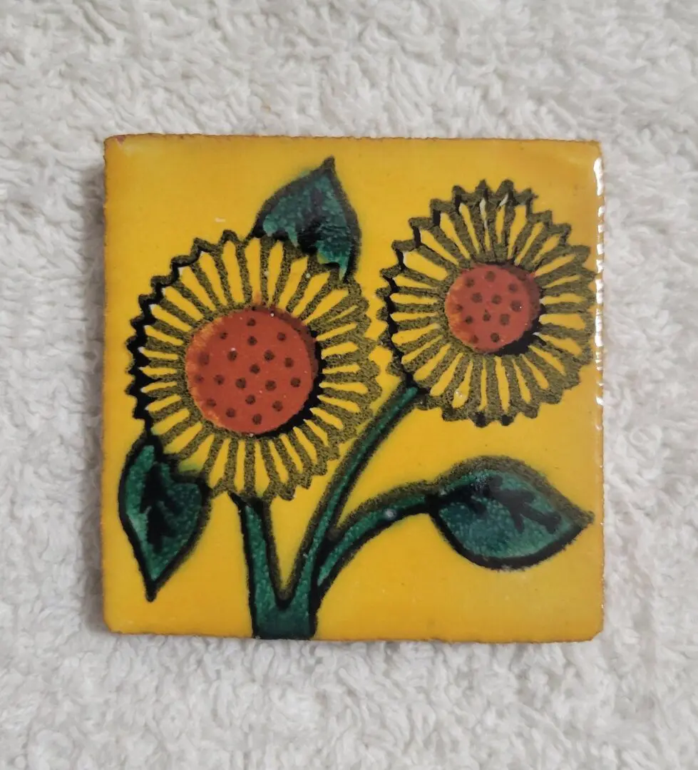 Square tile with hand-painted sunflowers on a yellow background.
