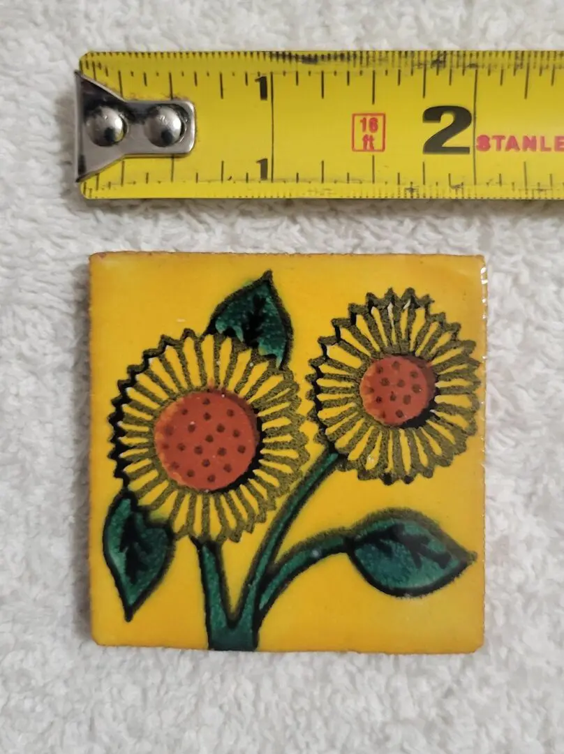 Decorative tile with two sunflowers and green leaves.