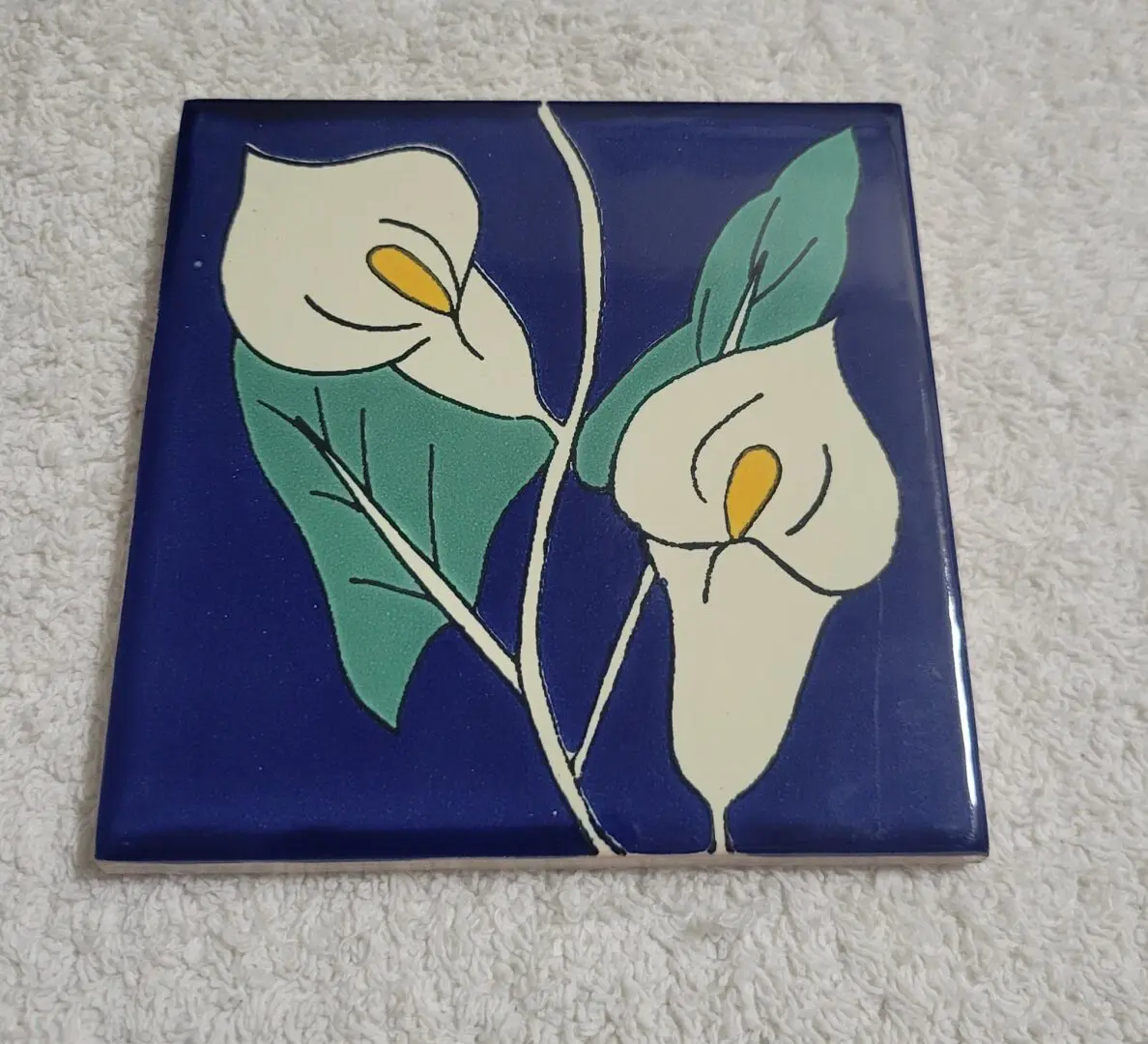 Floral tile with calla lilies on blue.