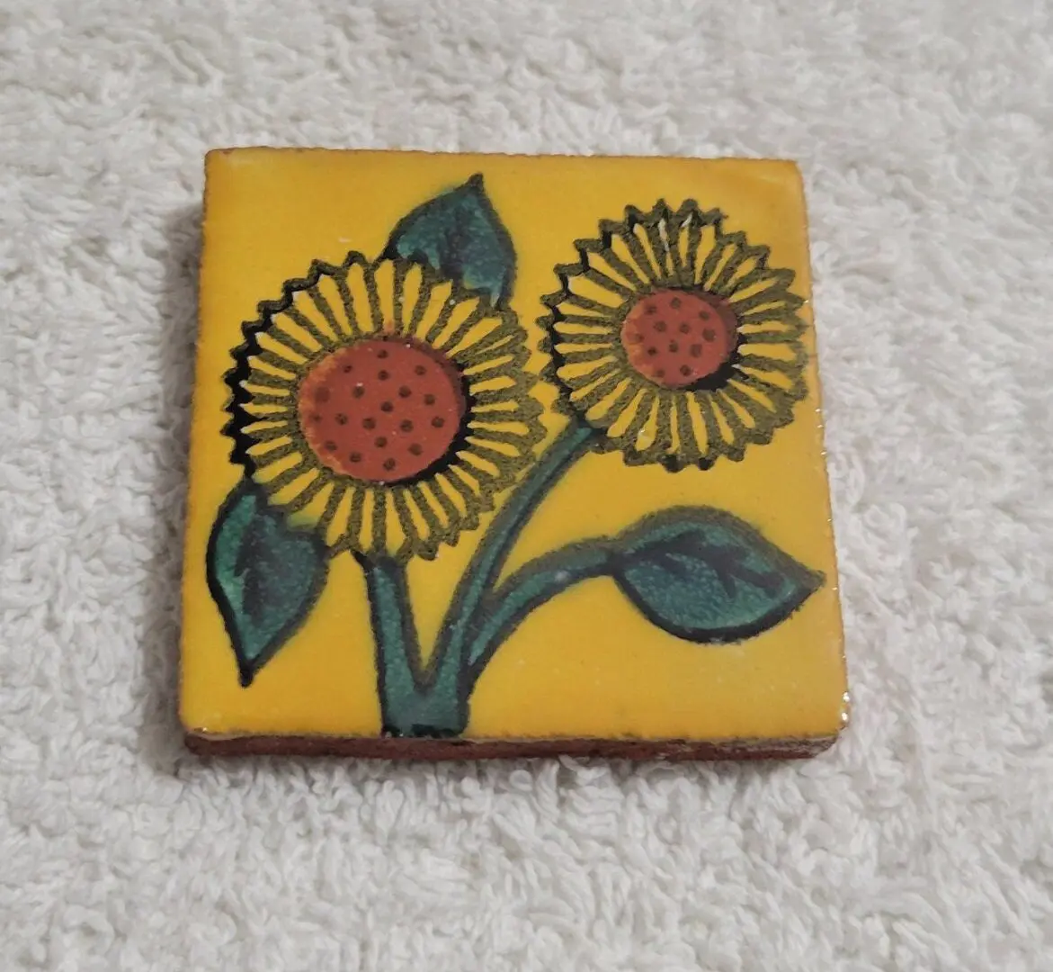 Decorative tile with two sunflowers on a yellow background.