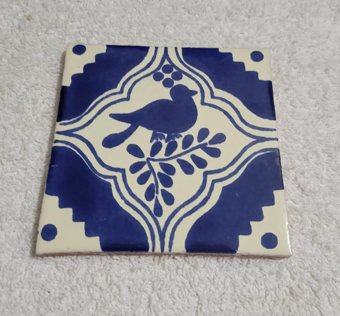 Blue bird design on decorative ceramic tile.