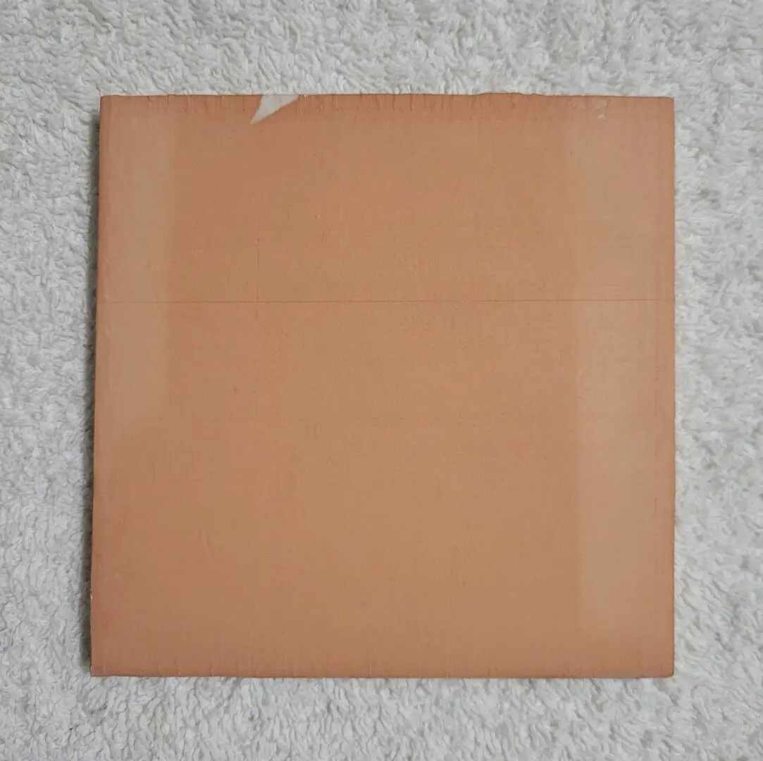 Square cardboard on textured white surface.