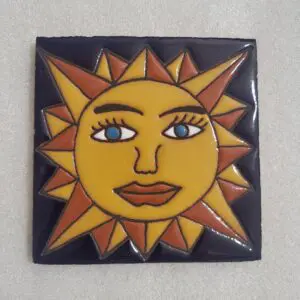 Stylized sun face on ceramic tile.