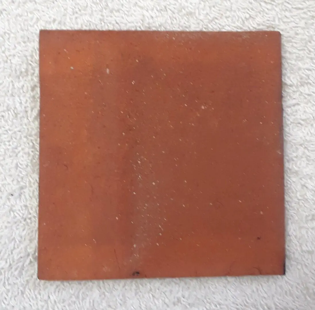 Square terracotta tile on beige fabric