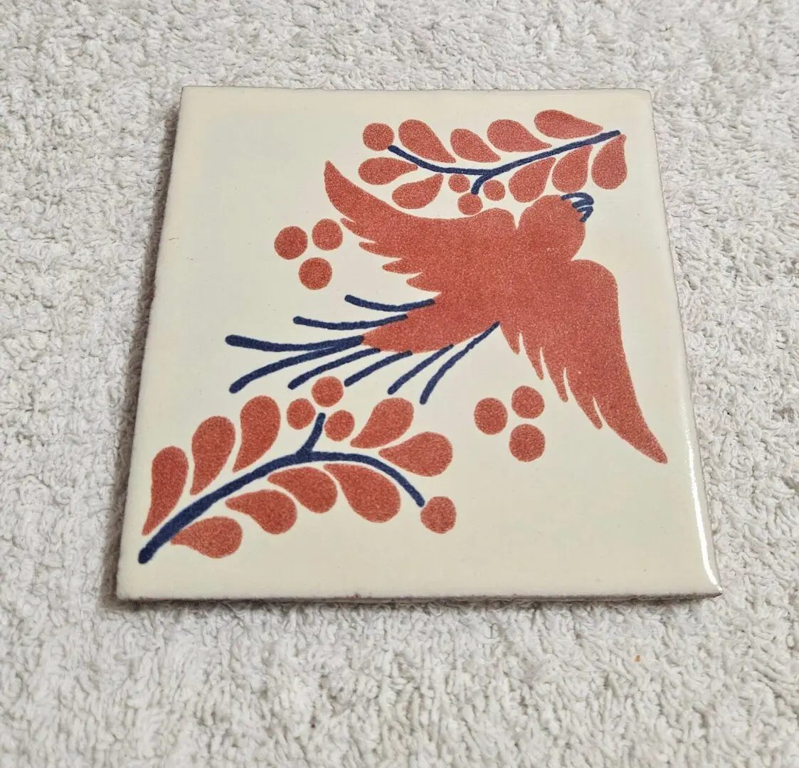 Decorative ceramic tile with stylized orange bird