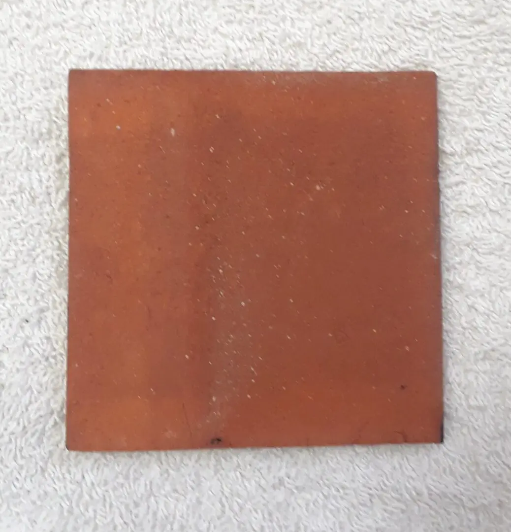 square terracotta tile on white towel