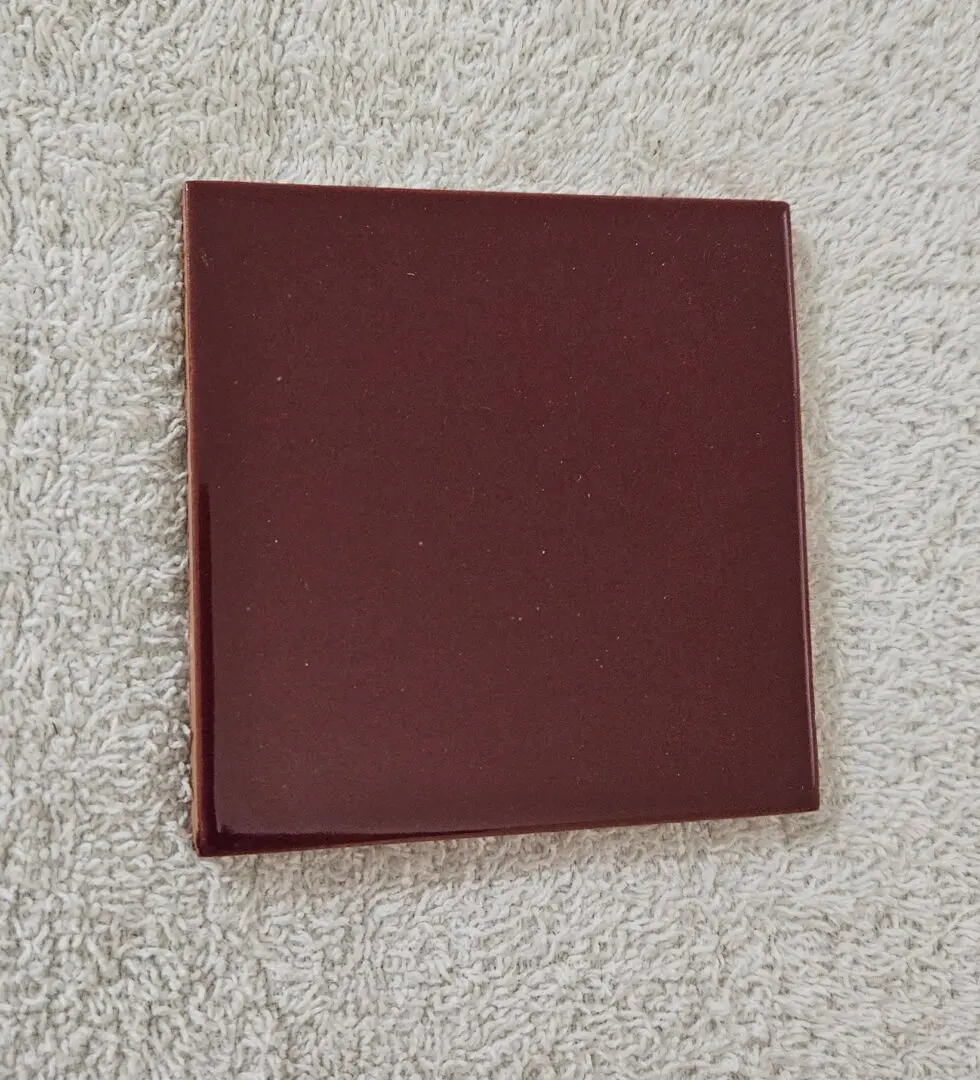 Closed maroon-colored book on a textured surface.
