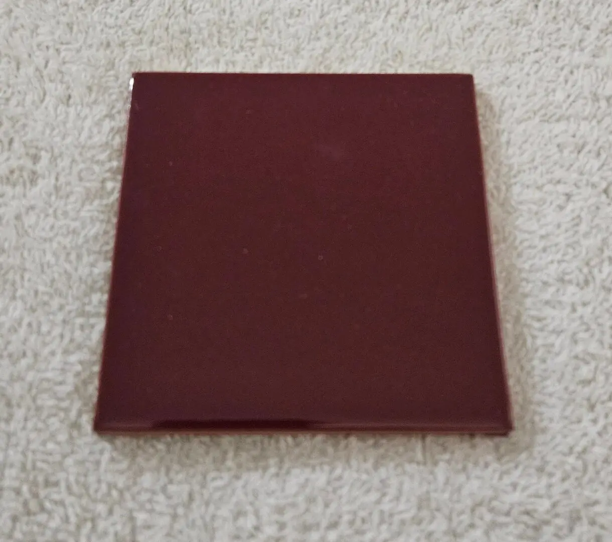 Closed maroon book on a light carpeted surface.