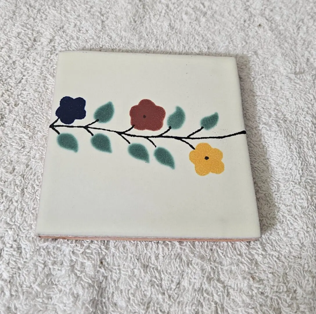 Tile with floral pattern on white background.