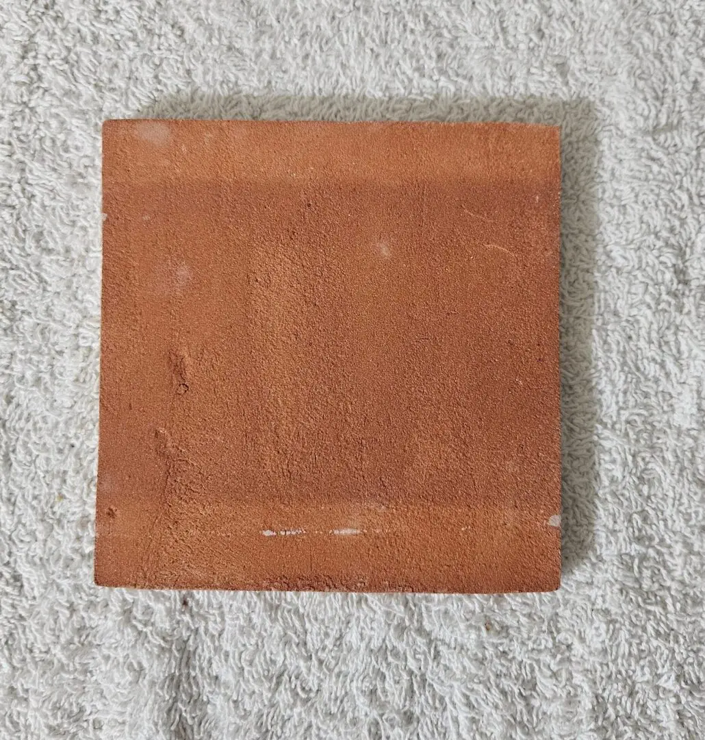 Square terracotta tile on textured towel